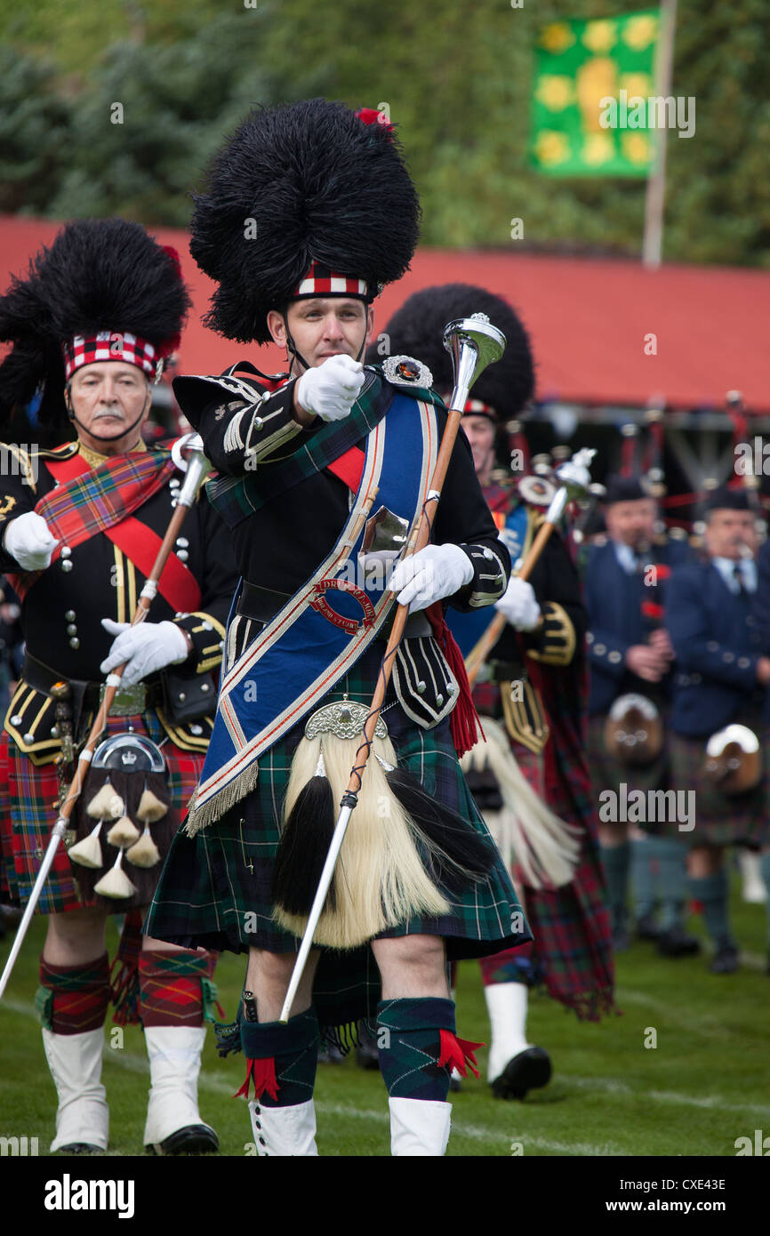 Villaggio di Braemar, Scozia. Grande tamburo Roland Stuart conduce la ammassato bande di cornamuse presso il Royal Braemar raccolta di giochi. Foto Stock