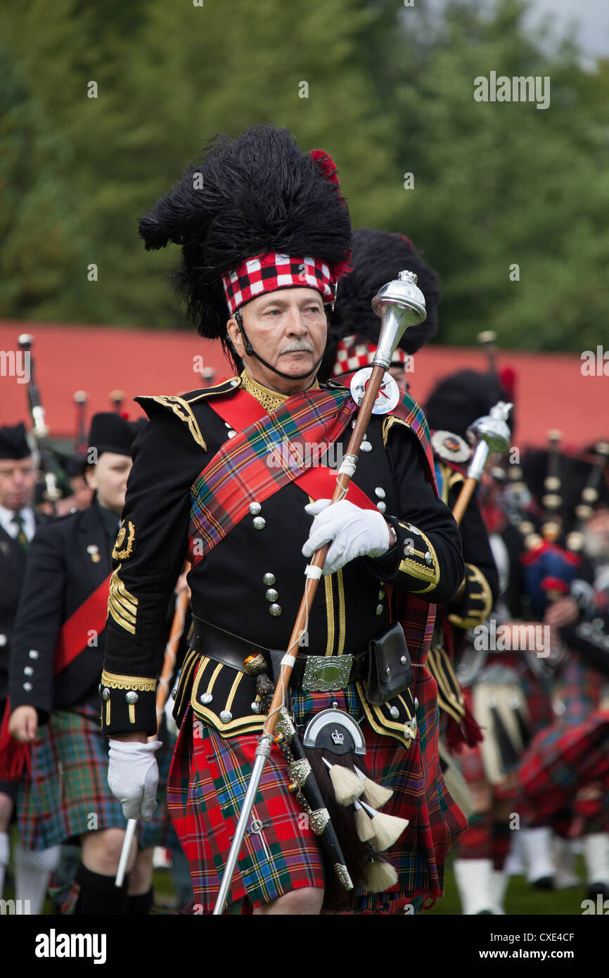 Villaggio di Braemar, Scozia. Grande tamburo Bert estati da Turriff & District Pipe Band marching intorno al Braemar arena. Foto Stock