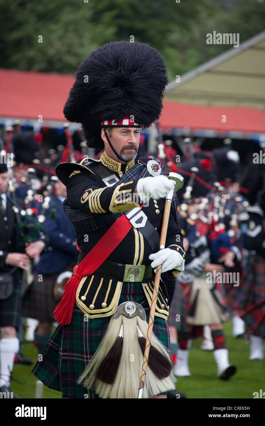 Villaggio di Braemar, Scozia. Un grande tamburo marciando con il tubo ammassato bande a Royal Braemar raccolta di giochi. Foto Stock
