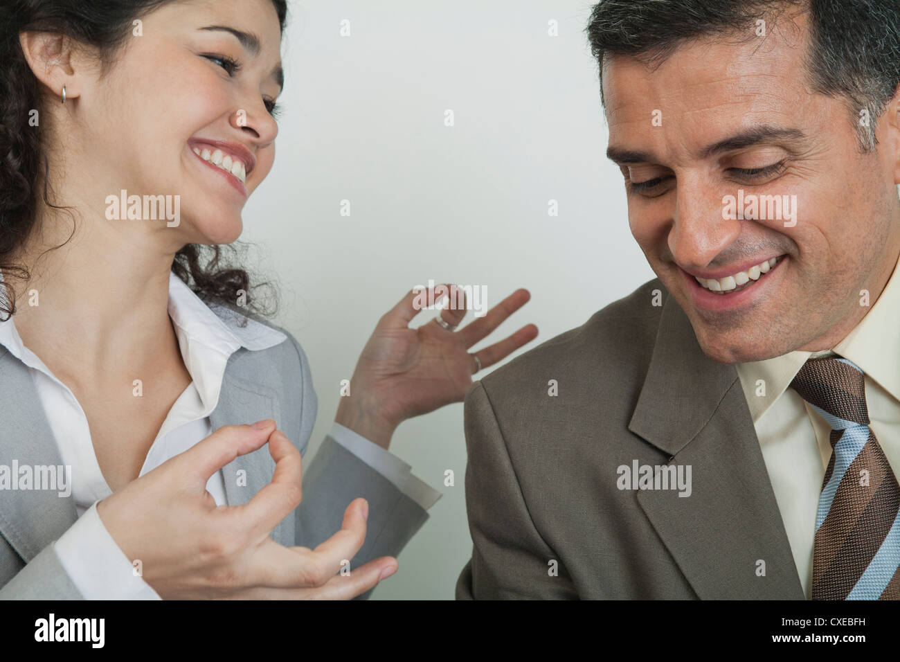 Business Associates ridere insieme, donna tenendo le mani nel mudra Foto Stock