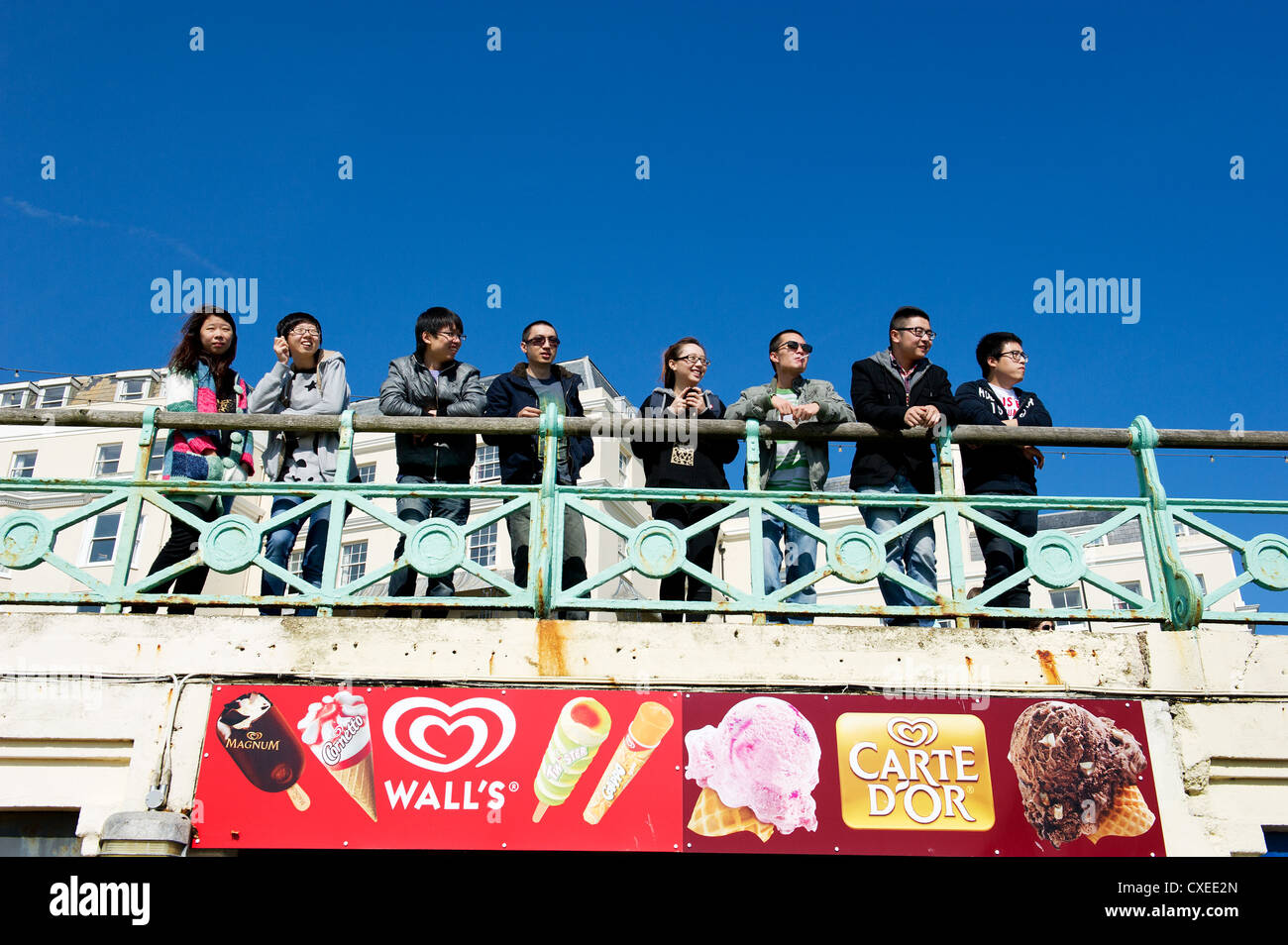 Un gruppo di giovani cinesi che sul lungomare di Brighton Foto Stock