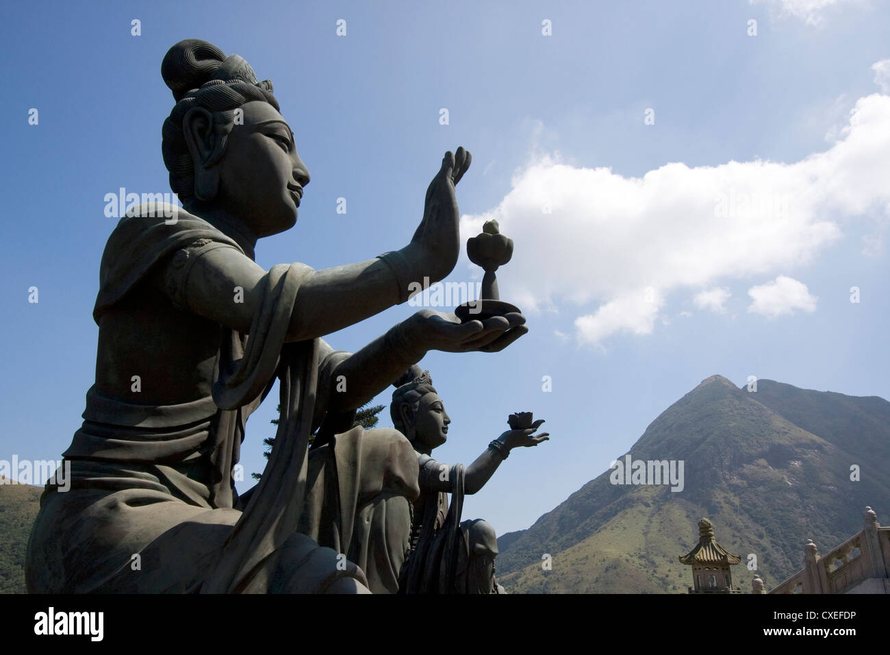 Statue Buddhistic lodare e fare offerte a Tian Tan Big Buddha, sull'Isola di Lantau, Hong Kong, Cina. Foto Stock