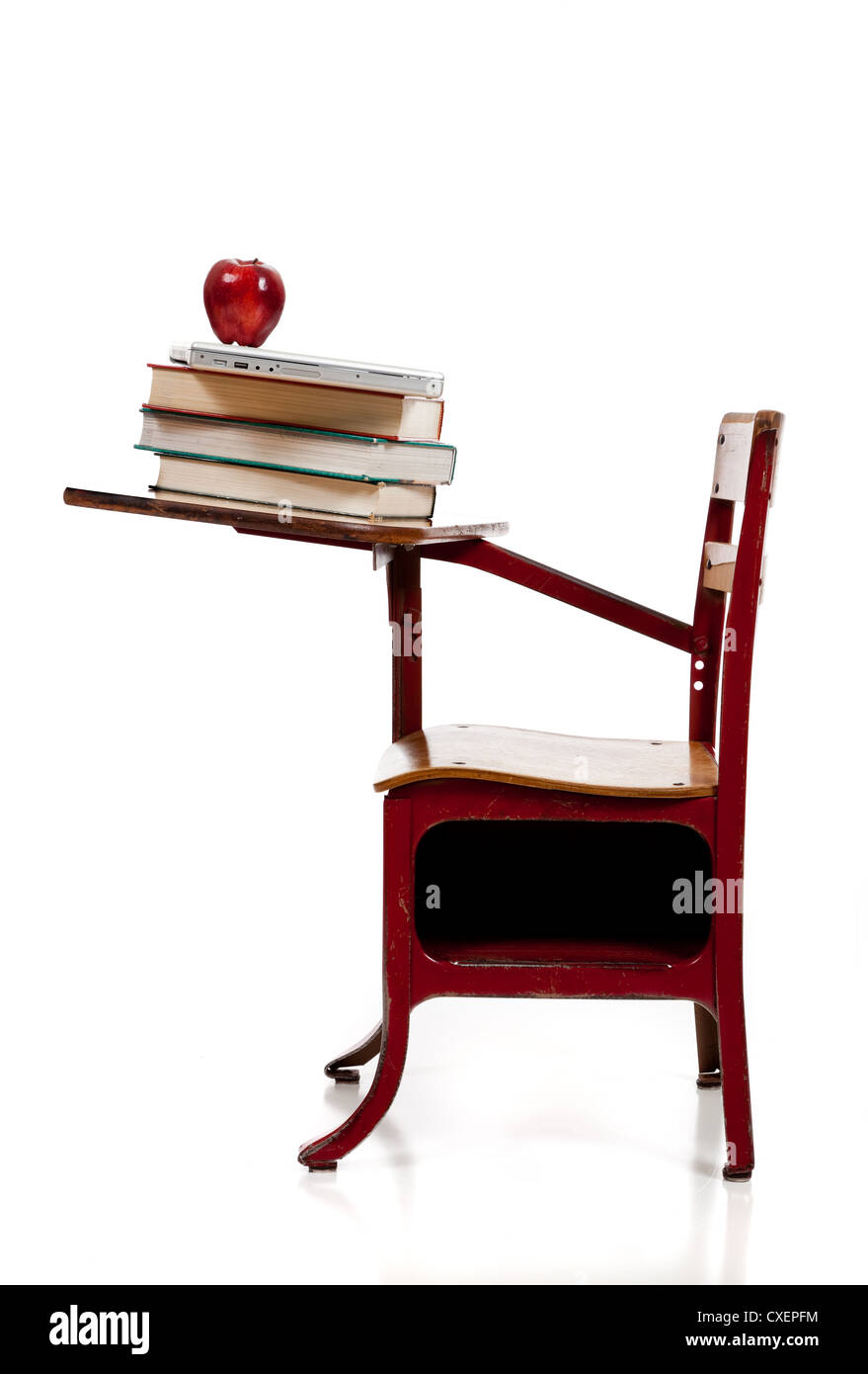 Un rosso vintage scrivania in legno con una pila di libri di testo e una mela su sfondo bianco Foto Stock