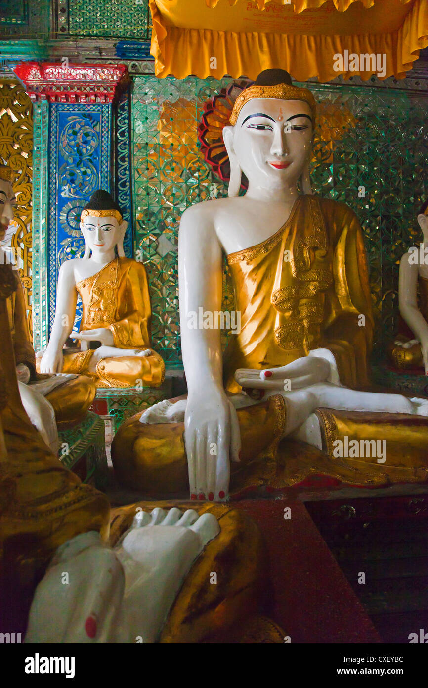 Statue di Buddha sono venerate presso la Shwedagon Paya o pagoda che risale al 1485 - YANGON, MYANMAR Foto Stock