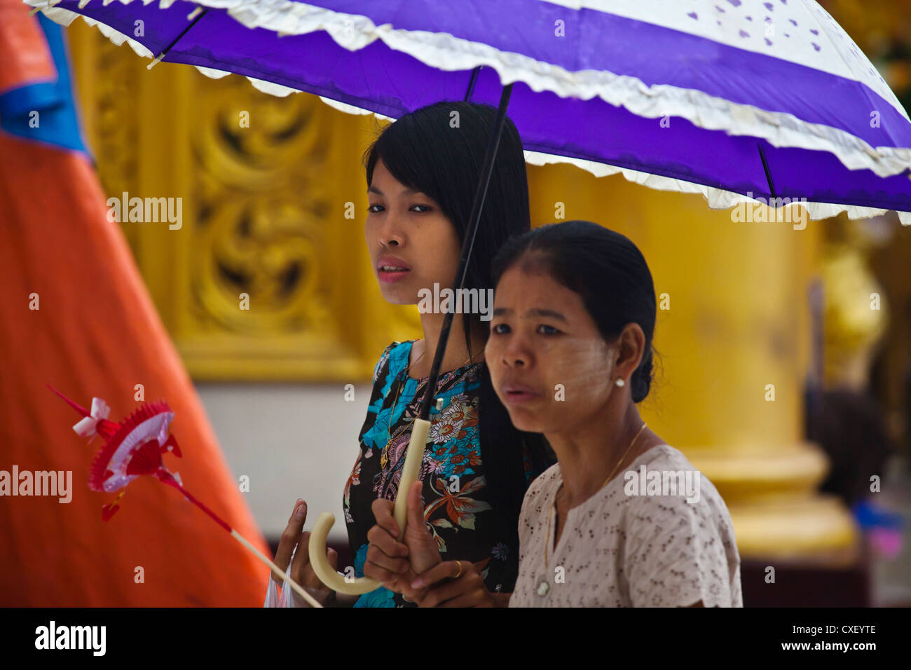 Donna birmano con ombrelloni a Shwedagon Paya o pagoda che date vack al Buddha - YANGON, MYANMAR Foto Stock