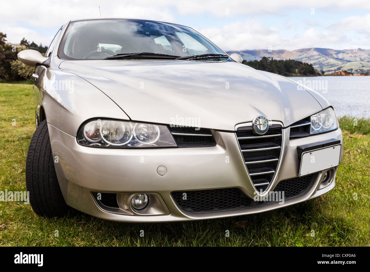 Color Champagne l'Alfa Romeo 156 Sportwagon, parcheggiata accanto al porto di Akaroa in Nuova Zelanda. Foto Stock