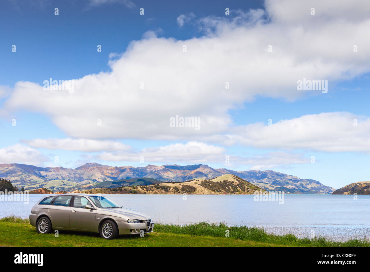 Color Champagne l'Alfa Romeo 156 Sportwagon, parcheggiata accanto al porto di Akaroa in Nuova Zelanda. Foto Stock