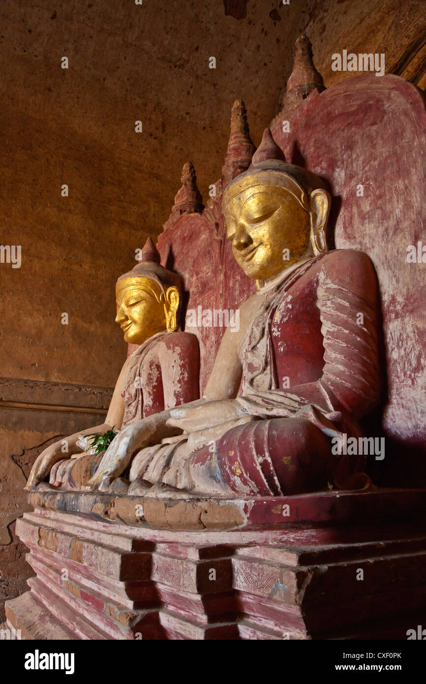 Fianco a fianco statue di Buddha nel XII secolo DHAMMAYANGYI tempio più grande in Bagan costruito probabilmente dal Narathu - Myanmar Foto Stock