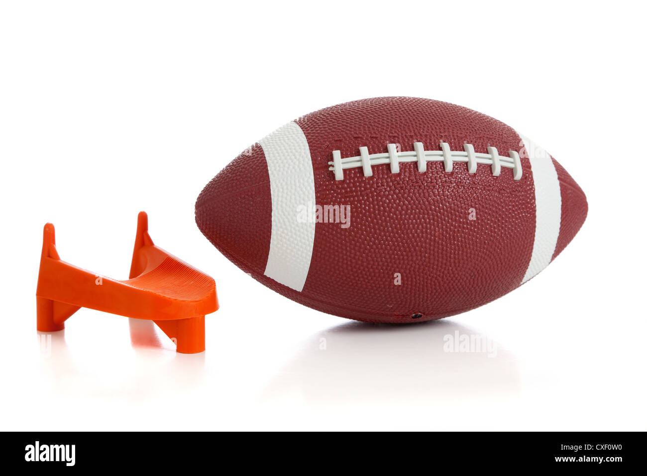 Football americano e un kicking tee su sfondo bianco Foto Stock