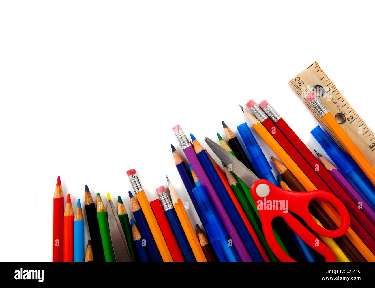 Fila di matite colorate e forniture scolastiche su uno sfondo bianco con spazio di copia Foto Stock
