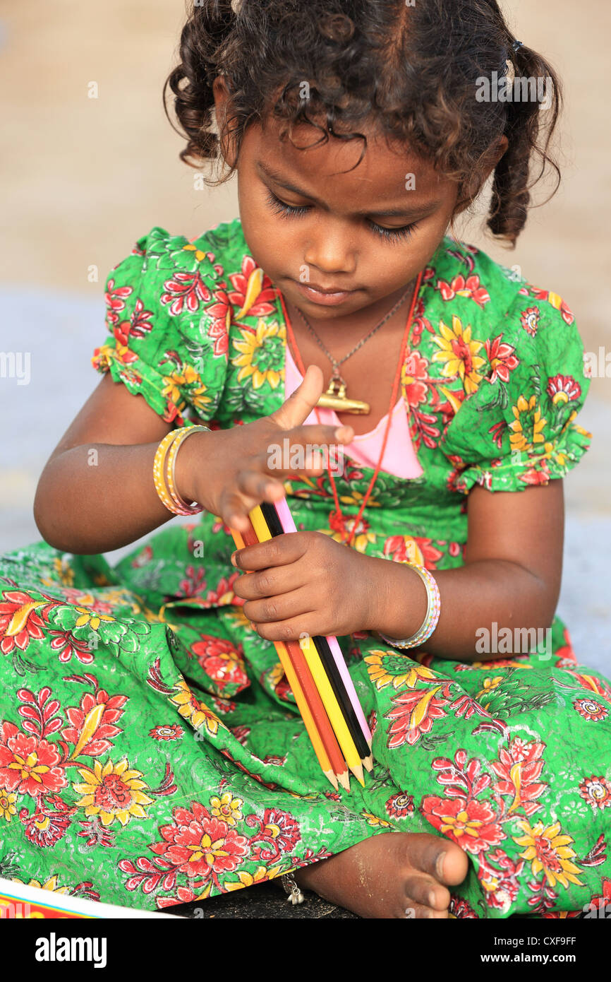 Little Indian School girl giocando con matite Andhra Pradesh in India del Sud Foto Stock