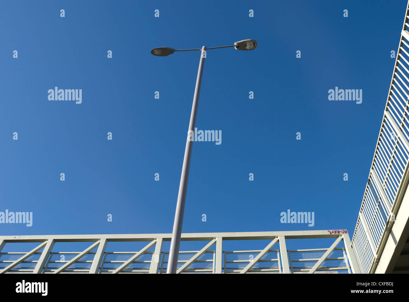 Lampione bidirezionale adajcent alla ringhiera di rilievo passerella pedonale in hanworth, middlesex, Inghilterra Foto Stock