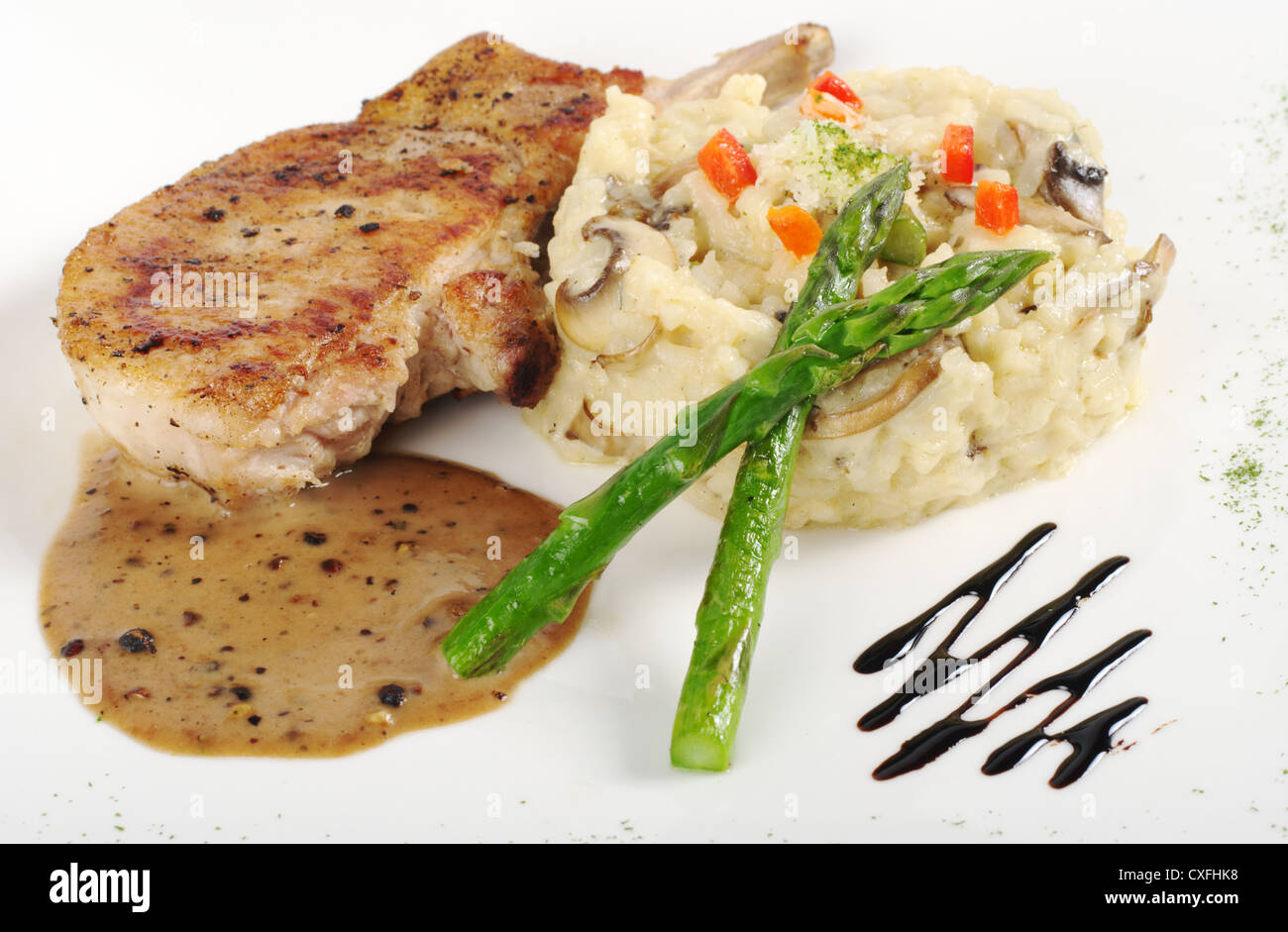 Il Risotto Asparagi verdi e la carne con il sugo di carne su un guarnito piastra bianca (messa a fuoco selettiva) Foto Stock
