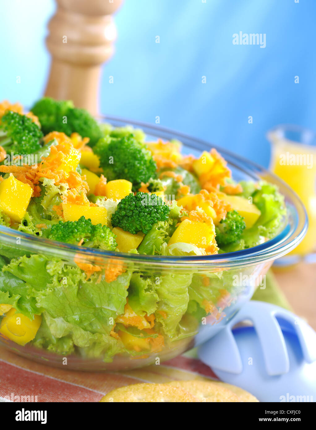Broccoli-mango--carota insalata di lattuga in una ciotola di vetro con insalata di server Foto Stock