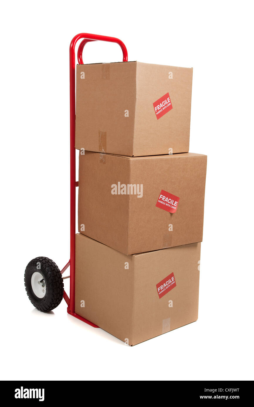 Pila di marrone scatole di imballaggio su una mano rossa carrello su sfondo bianco Foto Stock