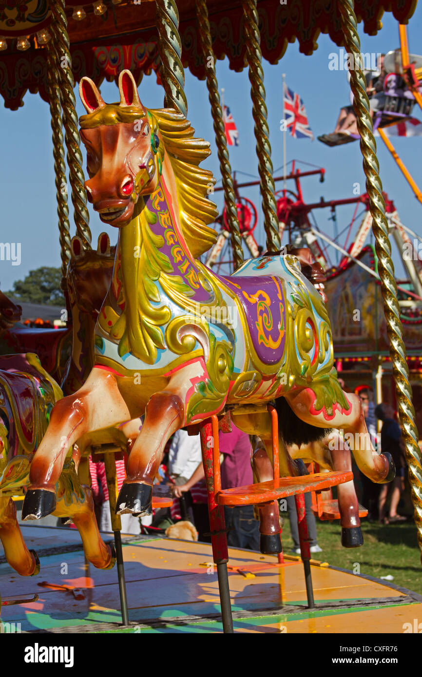 Una fiera carosello cavallo su un bagno di vapore alimentato ride shot nel Suffolk, Inghilterra Foto Stock