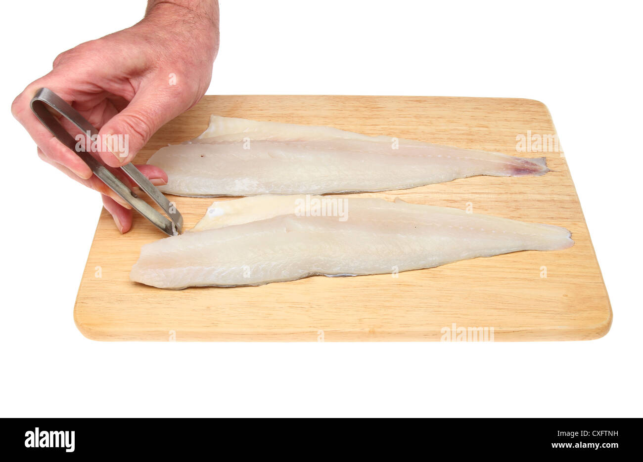 Pin a mano il disossamento i filetti di pesce su una tavola di legno isolata contro bianco Foto Stock