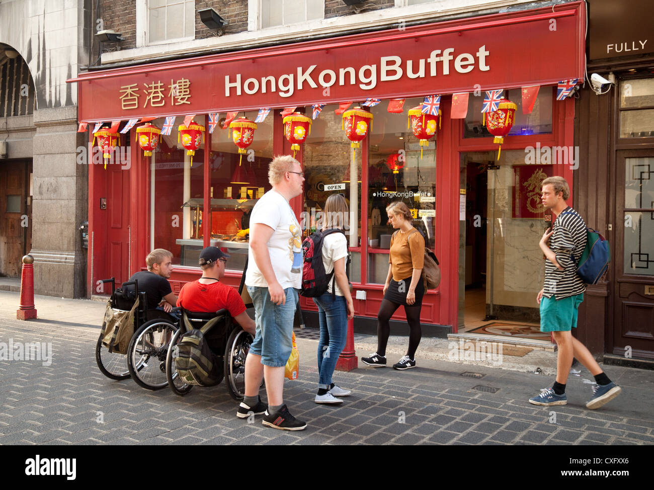 Le persone in sedia a rotelle al di fuori di un ristorante cinese, Gerrard St, Chinatown , London REGNO UNITO Foto Stock