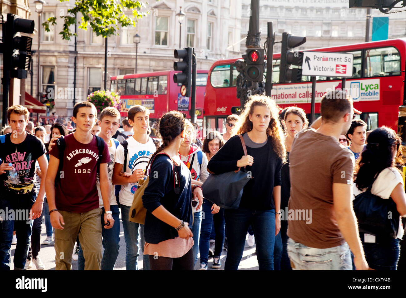 La gente britannica a Londra Inghilterra; una folla di pedoni che attraversano la strada, Trafalgar Square, Londra WC2, London City Centre, Londra UK Foto Stock