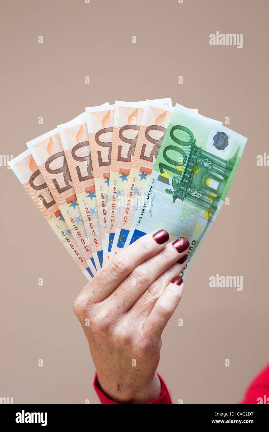 Donna che mantiene la denominazione di grandi dimensioni le banconote in euro in mano Foto Stock