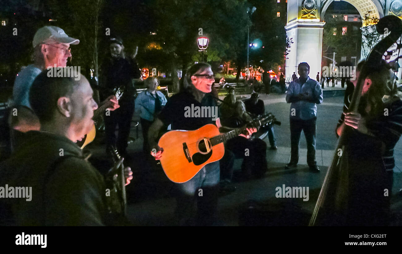 New York City, NY, USA, Greenwich Village, notte, musicisti di gruppo che suonano canzoni nel parco "Washington Square", ascoltano la folla cantando artisti di strada Foto Stock
