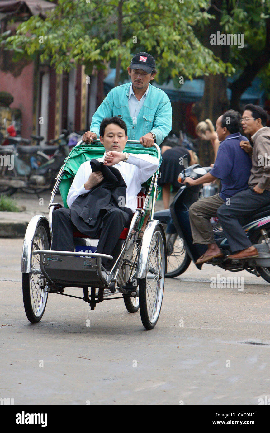 Il Vietnam, un passeggero in un rickshaw taxi Foto Stock