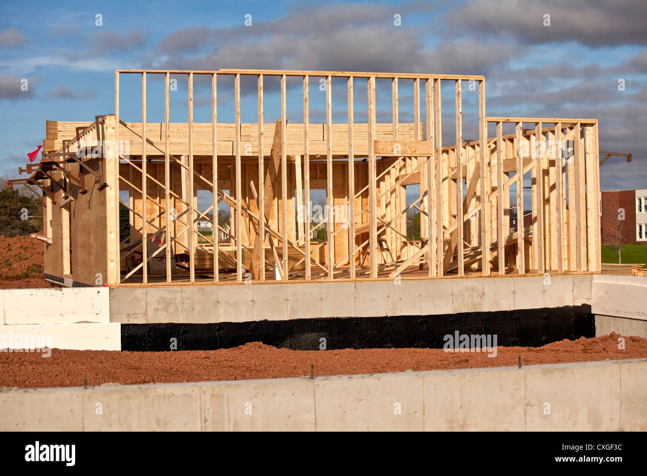 La costruzione di un telaio in legno abitazione o edificio con un isolato di fondazione in cemento. Foto Stock