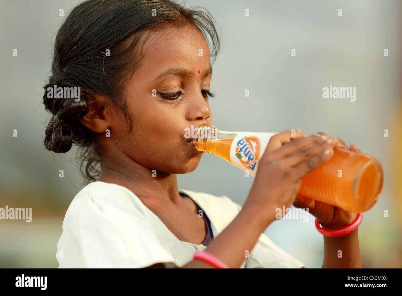 Ragazza indiana di bere una Fanta soft drink Andhra Pradesh in India del Sud Foto Stock