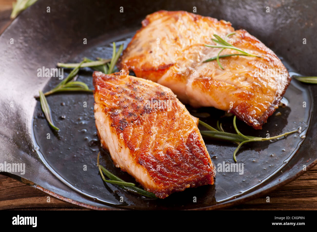 Filetti di salmone fritto in padella di ferro Foto Stock