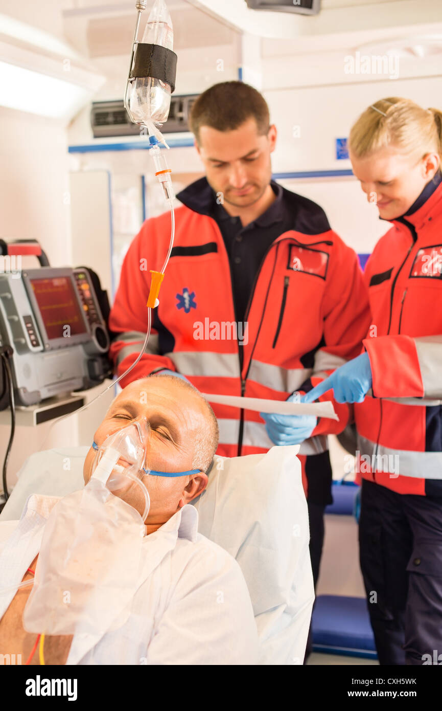 I paramedici LETTURA ECG in ambulanza paziente aiuto di emergenza uomo donna Foto Stock