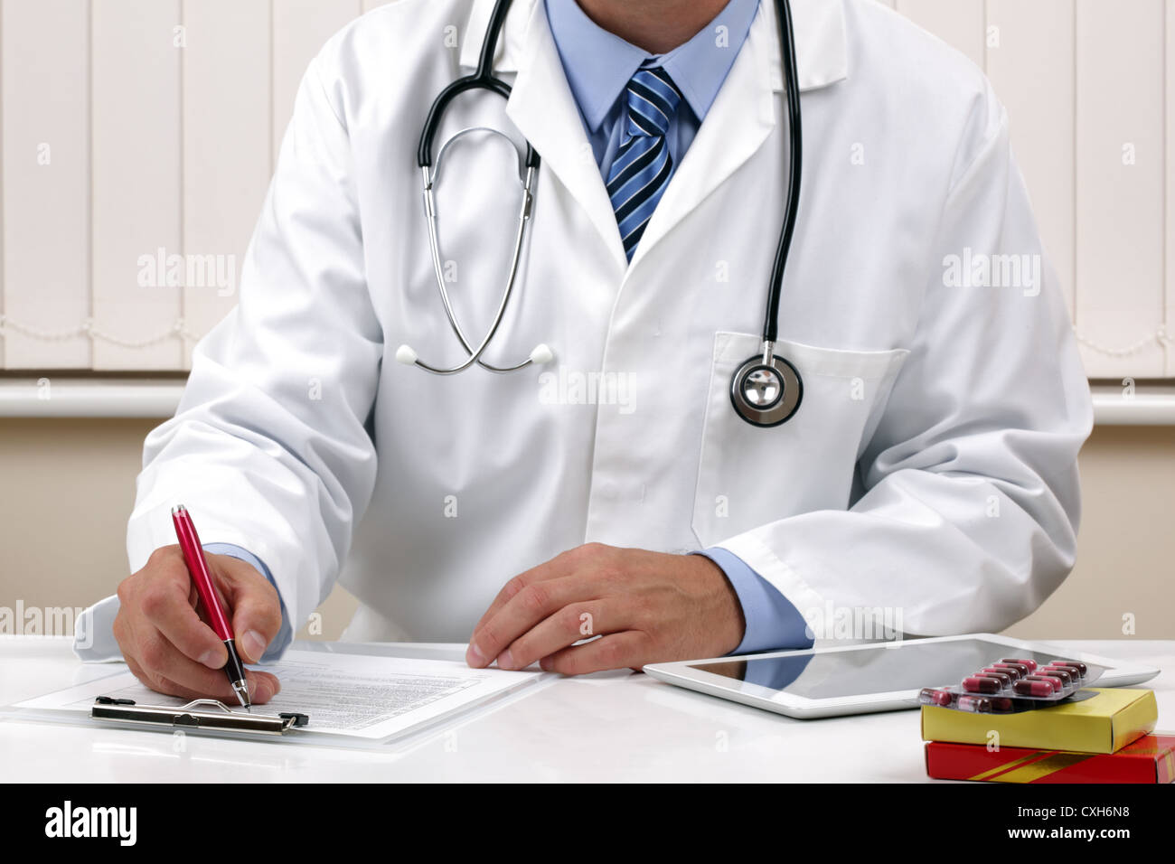 Medico iscritto una prescrizione medica o note di esame Foto Stock