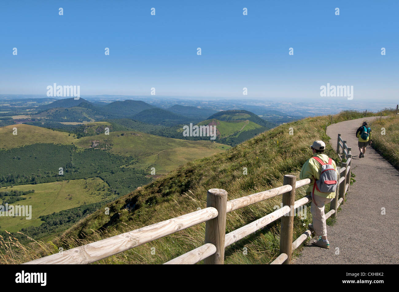 Escursionista guardando la vista dal Puy-de-Dome sul paesaggio vulcanico della Chaine des Puys, Auvergne, Francia. Foto Stock