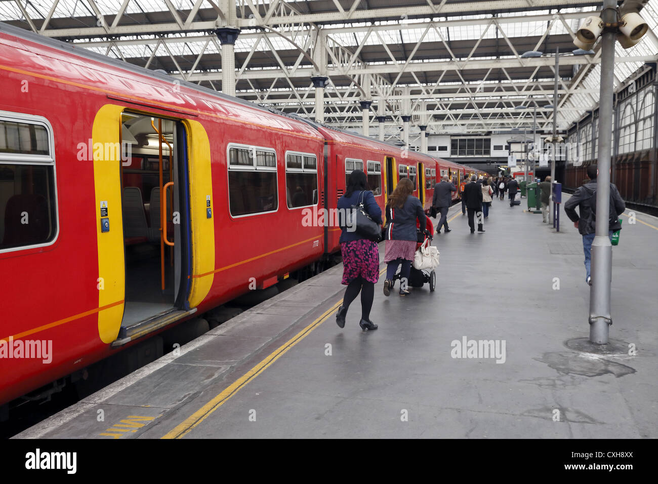 I passeggeri di scendere di un treno alla stazione di Waterloo. Foto Stock