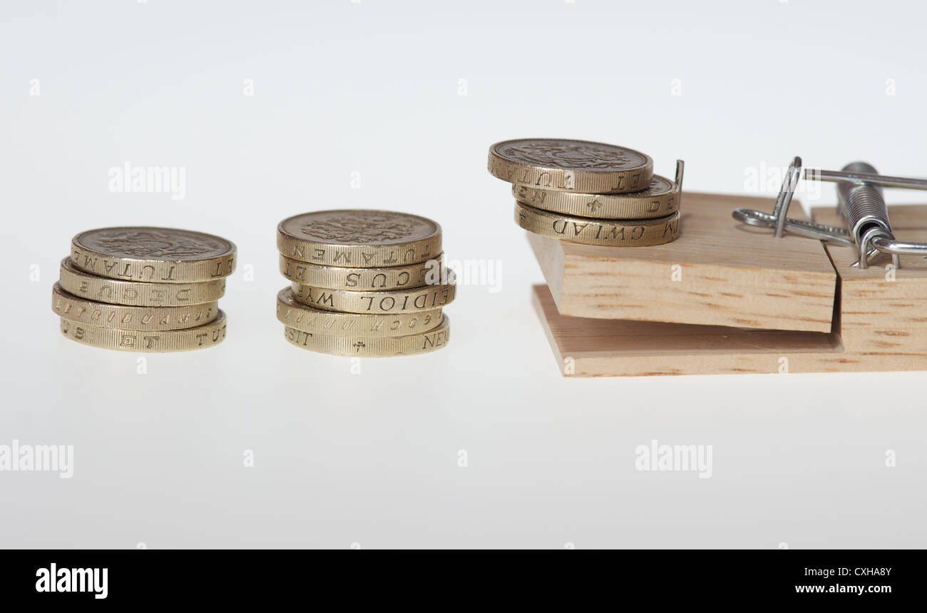 British una libbra di monete impilate con un mousetrap. Potrebbe simboleggiare il denaro problemi o intrappolati in debito Foto Stock