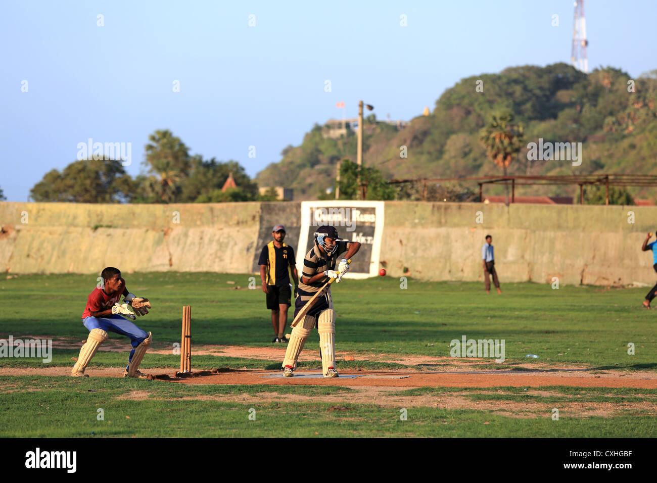 Giovani uomini la riproduzione di un gioco di pratica di cricket di Trincomalee, Sri Lanka. Foto Stock