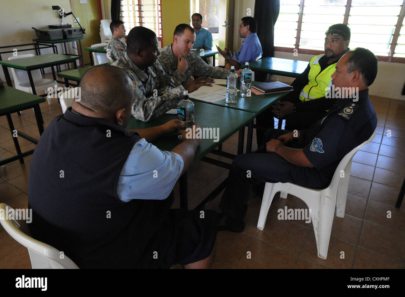 Maj. jay emerson e chief warrant officer jeremy drage dell'esercito degli Stati Uniti del Pacifico Comando di emergenza post assistenza umanitaria team sondaggio lo scambio di informazioni e di idee con i membri della tonga servizi antincendio, aeroporti e pacific energia a taliai accampamento militare, Tonga, sept. 25, 2012. Essi prendono parte in â€oecoral reef,â€ una multinazionale di distribuzione di emergenza esercizio disponibilità a condividere la fornitura di assistenza umanitaria e di soccorso in caso di catastrofe le tecniche e le procedure con i partner del Pacifico da Australia e Nuova Zelanda e Tonga. Foto Stock