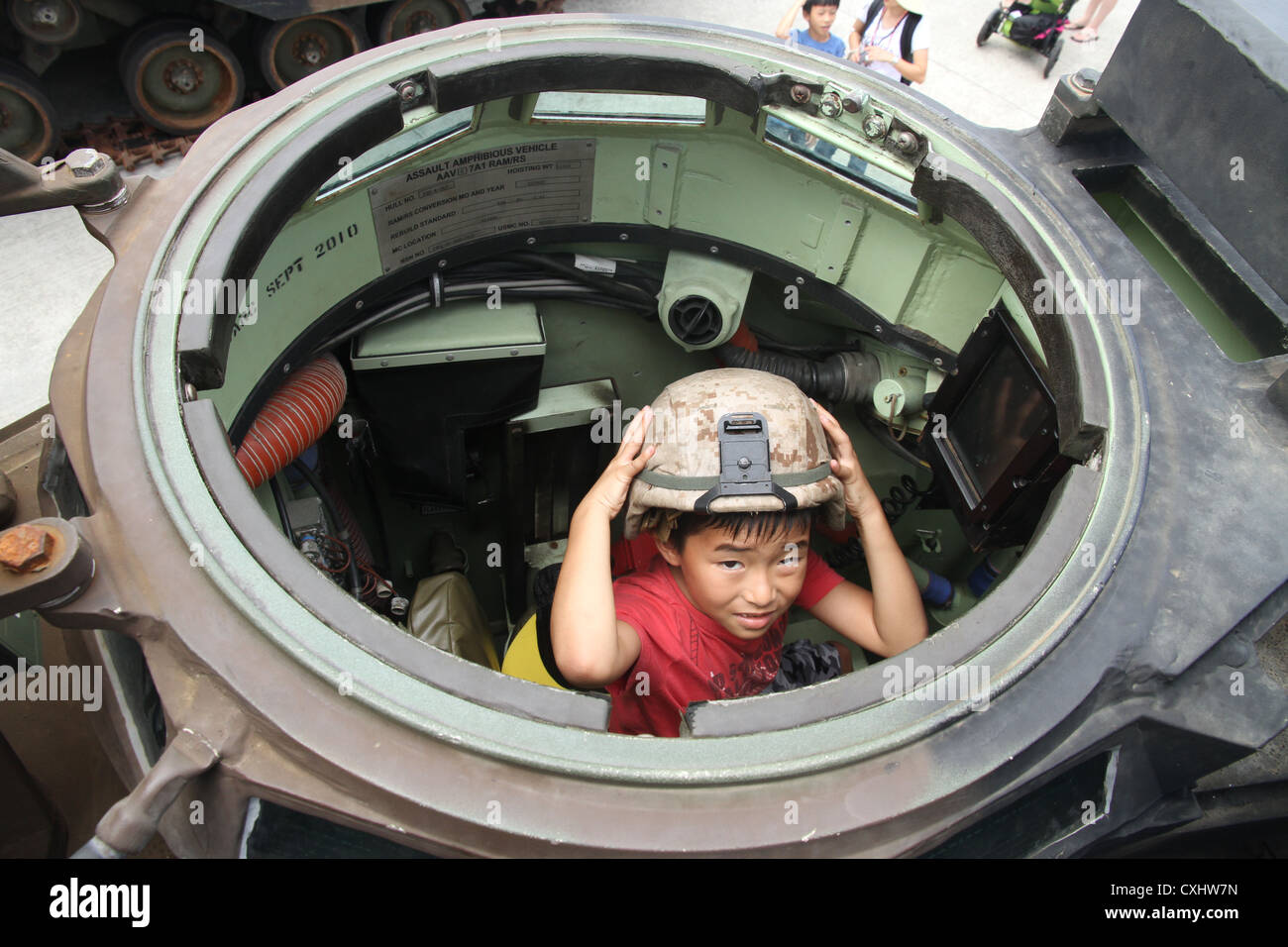 Un bambino indossa un kevlar nel pozzetto di un assalto veicolo anfibio durante il 2012 kaneohe bay air show il marine corps air station, kaneohe bay, Hawaii, sept. 30, 2012. La Baia di Kaneohe airshow è una due giorni di manifestazione in cui i visitatori possono testimoniare esibizioni aeree da militari e civili di aeromobili. Foto Stock