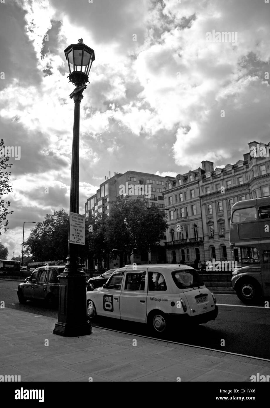 Il traffico su Piccadilly vicino parco verde che mostra iconico Londra cabina, City of Westminster, Londra, Inghilterra, Regno Unito Foto Stock