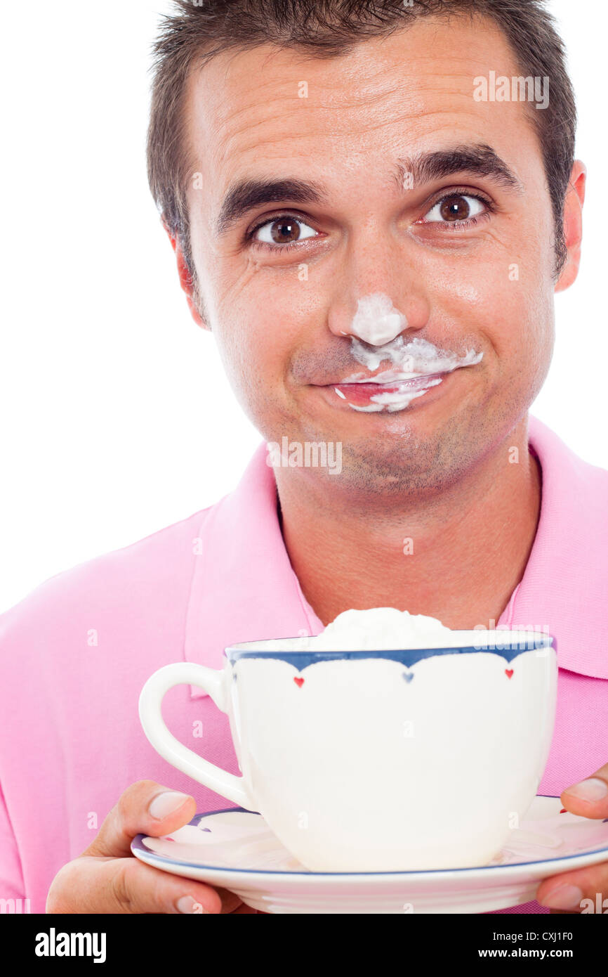 Close up funny man holding tazza di caffè con panna montata sul suo volto. Foto Stock