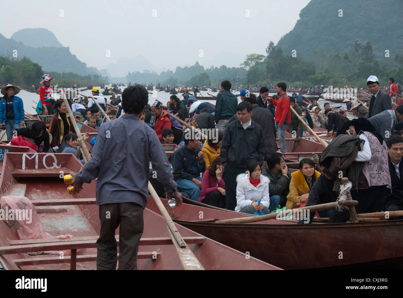 Barche sul fiume prendendo i devoti alla Pagoda Profumata, vicino Hanoi, Vietnam Foto Stock