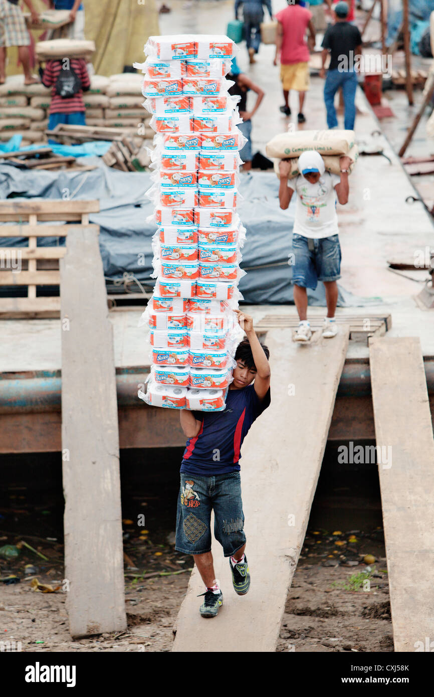 L'uomo trasporto di merci nel porto di Iquitos, Amazon, Perù. Foto Stock