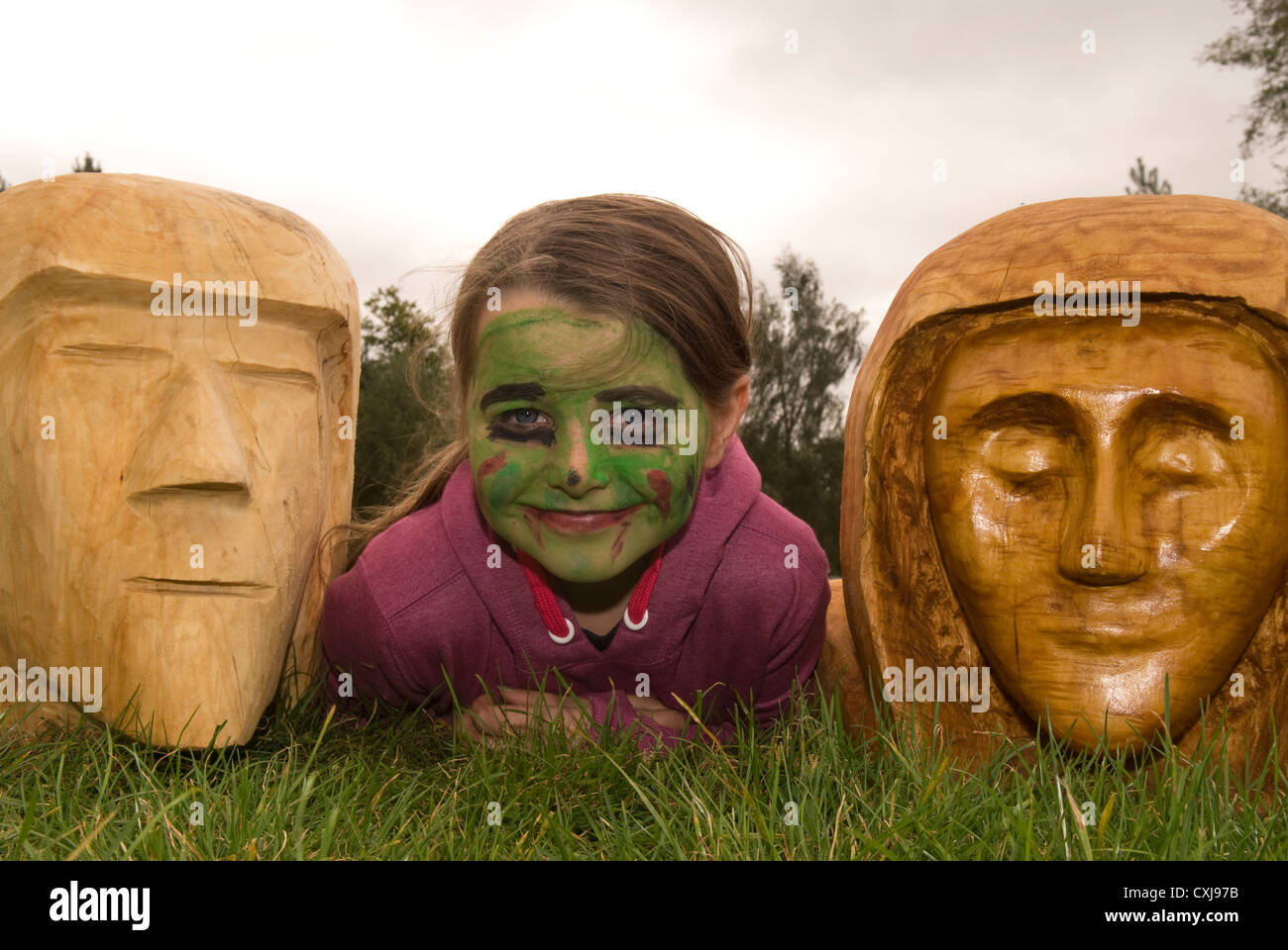 8 anno vecchia ragazza che stabilisce tra 2 chainsaw sculture in legno ad  una commissione forestale scoperta giorno Foto stock - Alamy