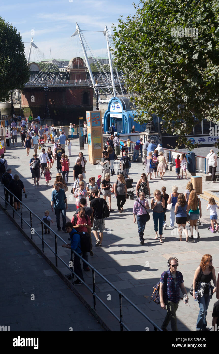 Folla estiva a piedi lungo il fiume presso il South Bank Foto Stock