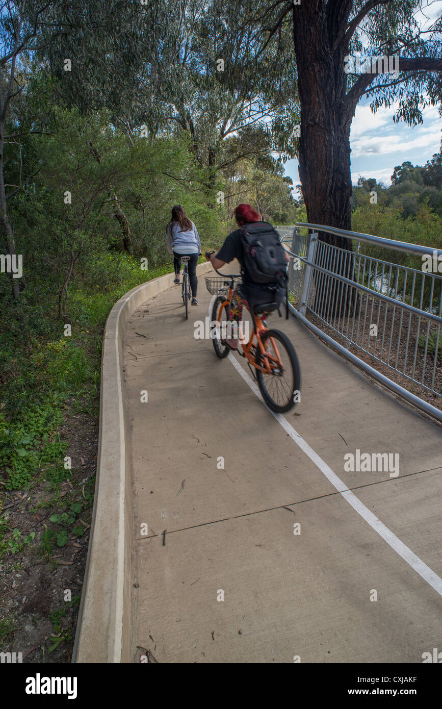 Ciclista e del jogging in curva Yarra park Foto Stock