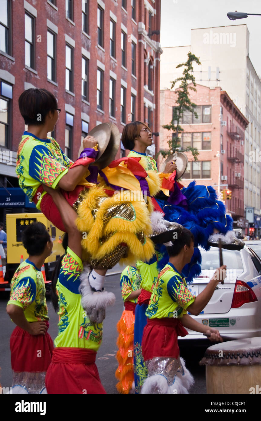 Ballerini cinesi di eseguire una danza leone in una strada di Chinatown - New York City, Stati Uniti d'America Foto Stock