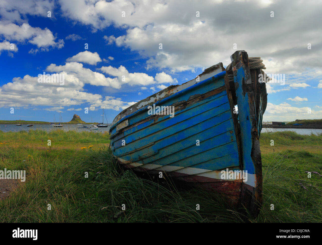 La barca di legno sull Isola Santa con il castello visibile in background. Foto Stock