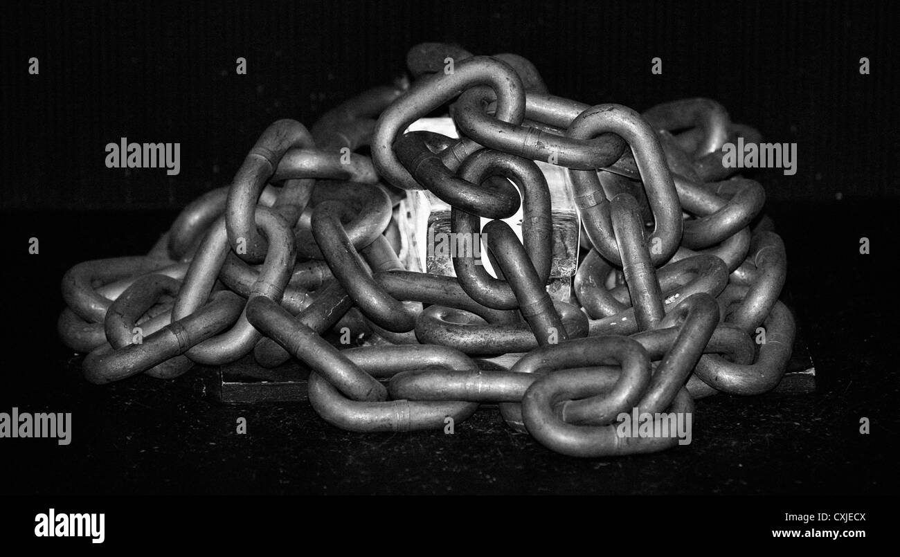 Immagine in bianco e nero di una lampada in vetro circondata da catene in acciaio Foto Stock