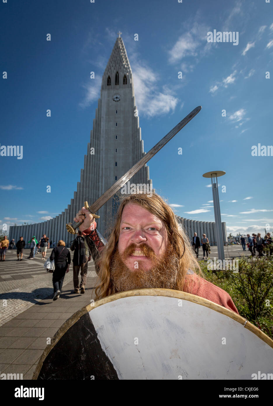 Viking con spada e scudo, Reykjavik del festival culturale( Menningarnott) Chiesa Hallgrimskirkja in background, Islanda Foto Stock