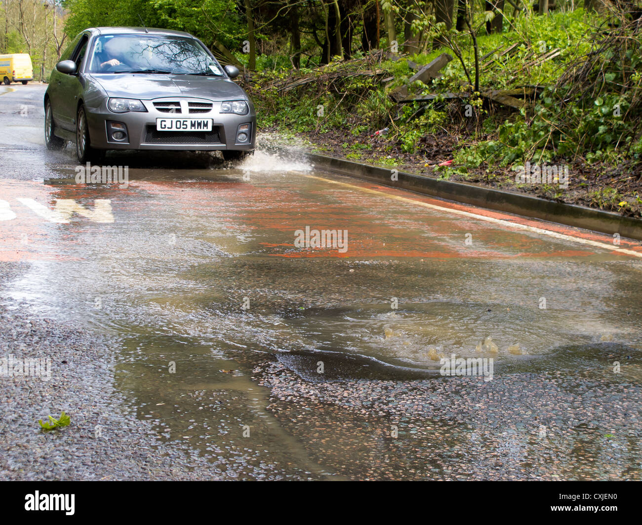 Inondazioni in una strada di campagna vicino a Nutfield marsh causando problemi per auto Foto Stock