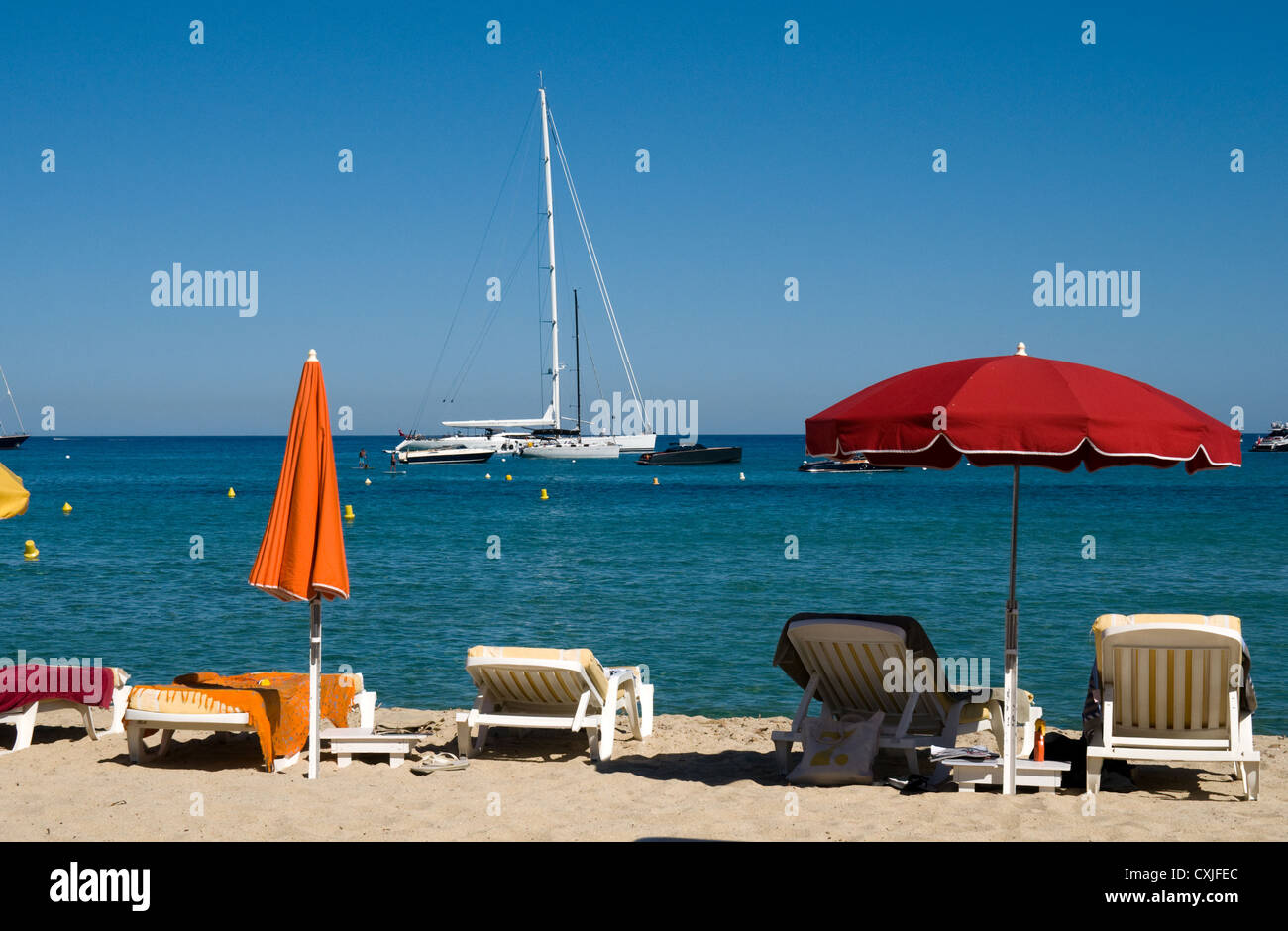 Lettini da sole e ombrelloni sulla sabbia dorata della spiaggia di Pampelonne vicino a St Tropez nel sud della Francia Foto Stock